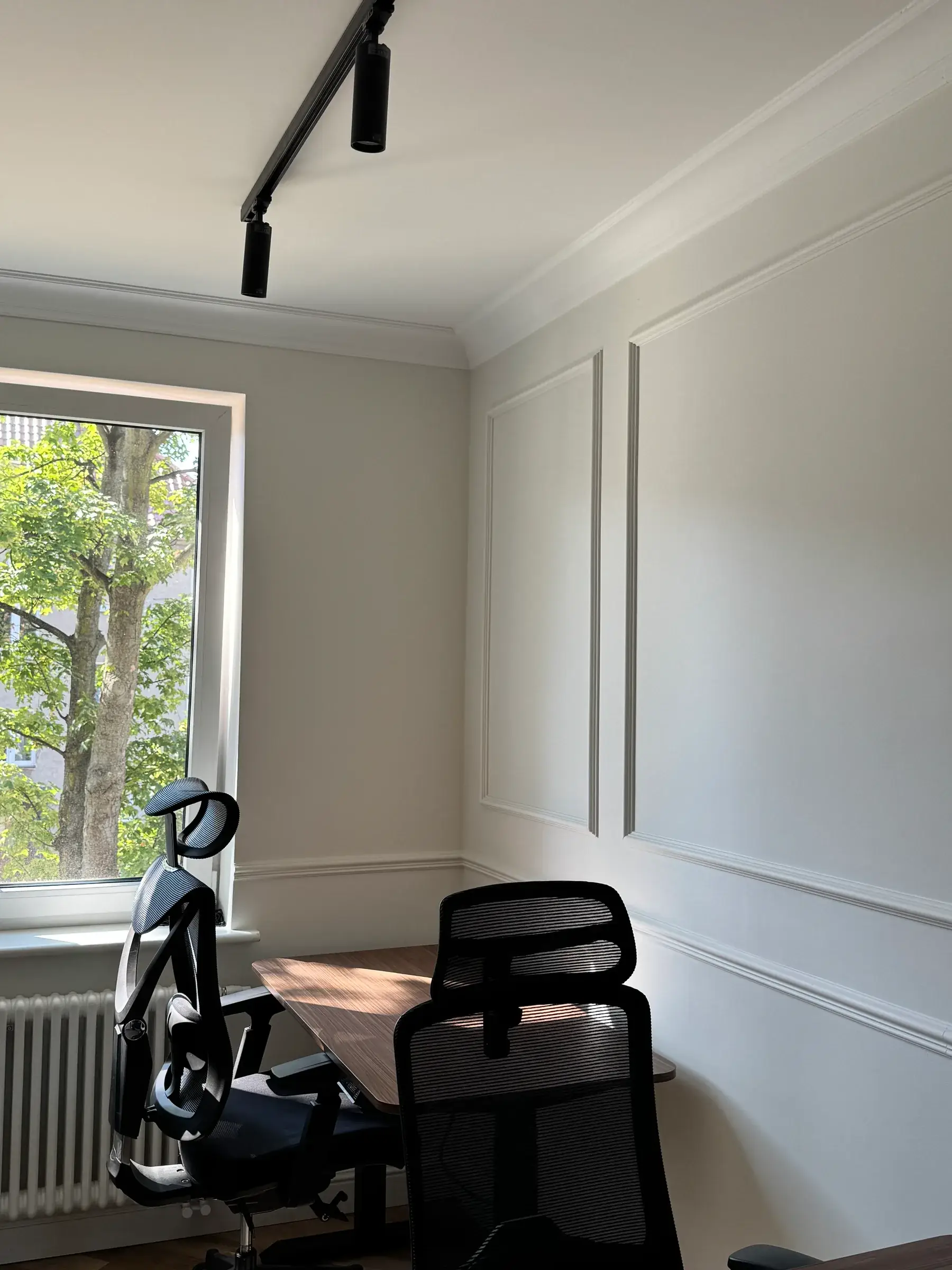Stanowisko pracy z ergonomicznym fotelem przy ścianie ze sztukaterią